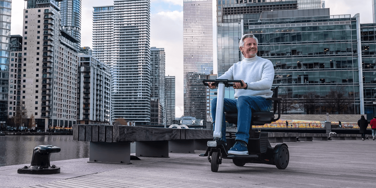 Man in a city on the WHILL Model R mobility scooter.