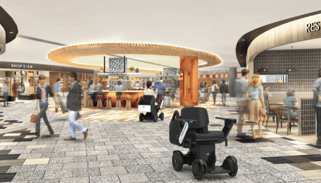 Spacious modern airport interior featuring people walking around and WHILL's autonomous service power chair self driving around.