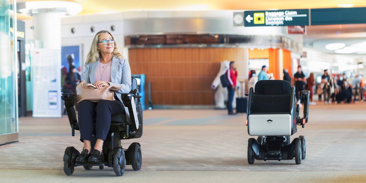 Women at the airport in the WHILL autonomous service powerchair.