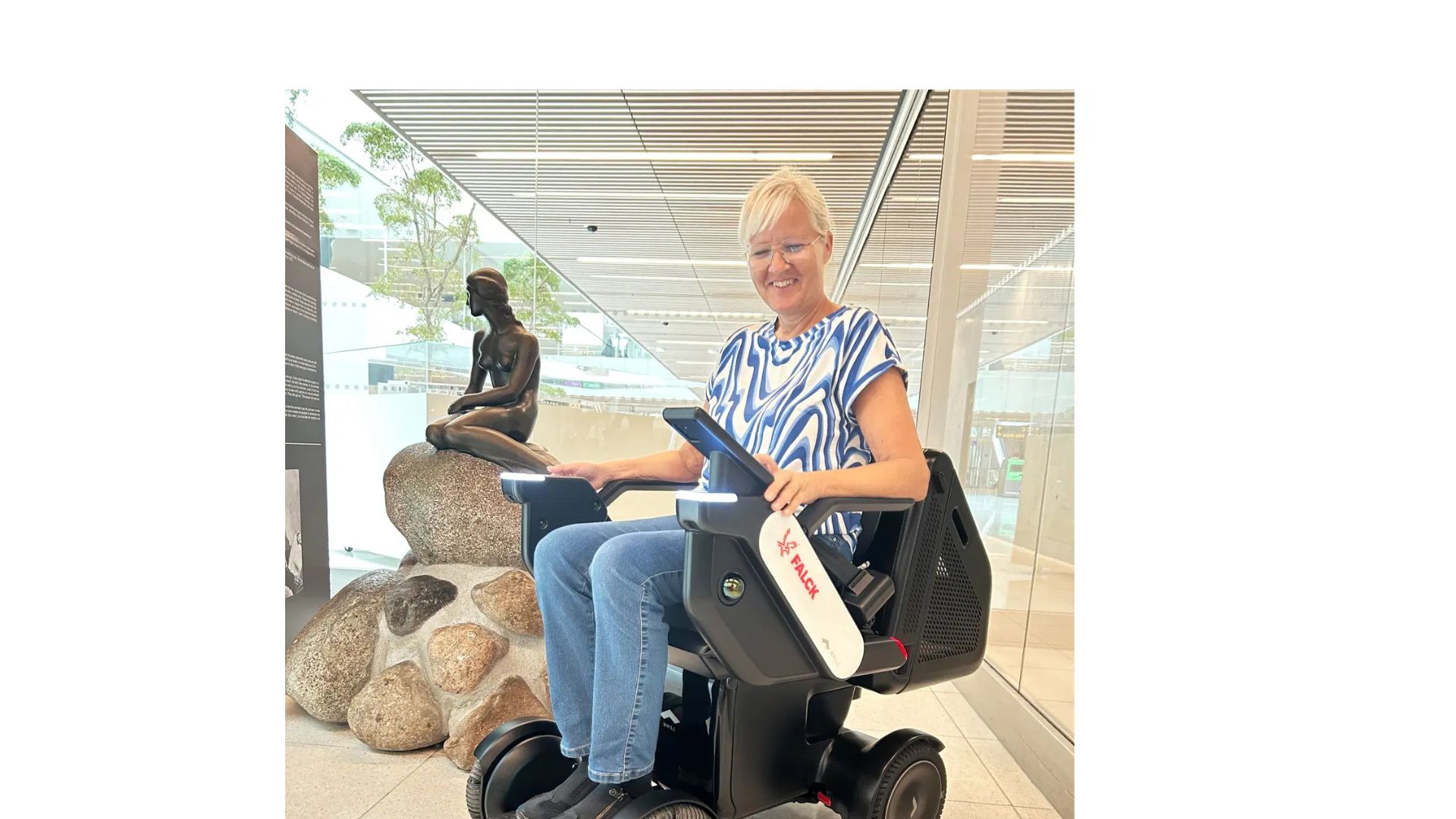 Women in WHILL autonomous service device in the airport