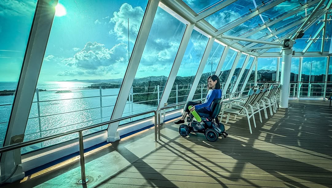 Woman on a cruise ship sitting in a WHILL Model C2 portable powerchair.